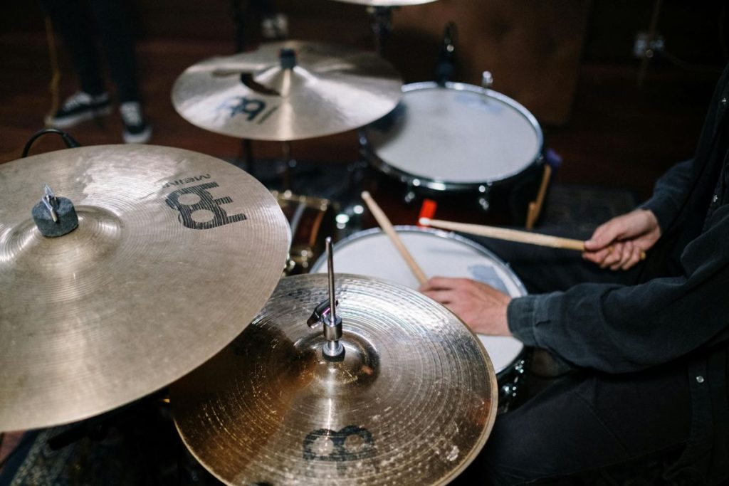 A drummer energetically playing drums in a recording studio.