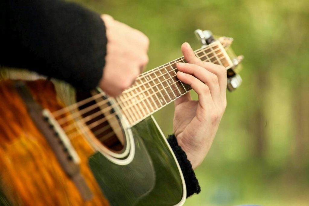 A person playing an acoustic guitar.
