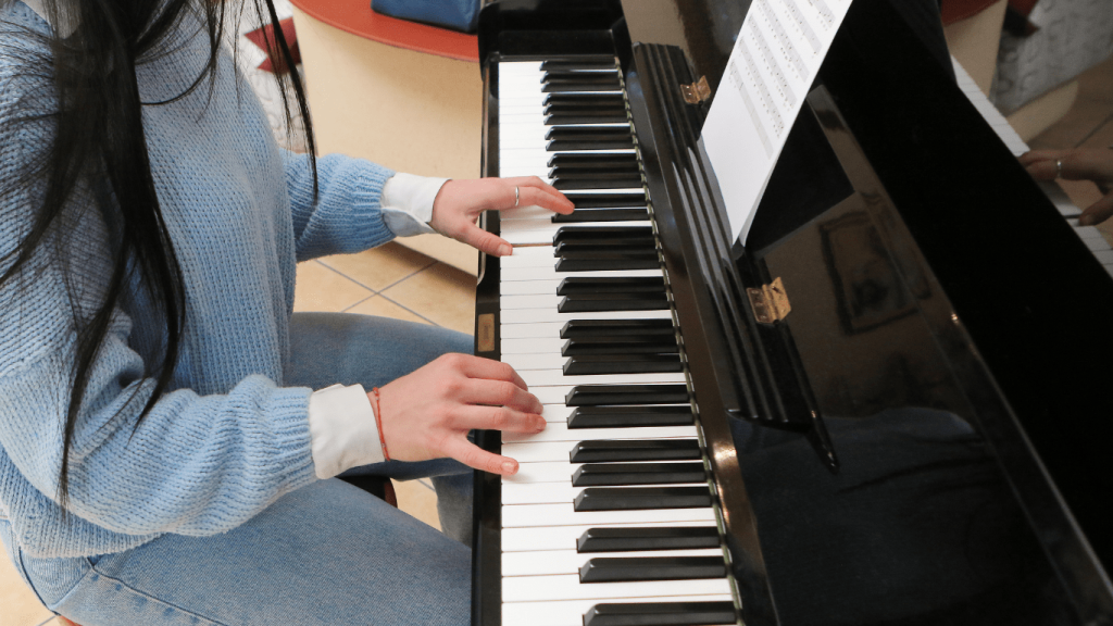 Woman playing the piano while reading sheet music