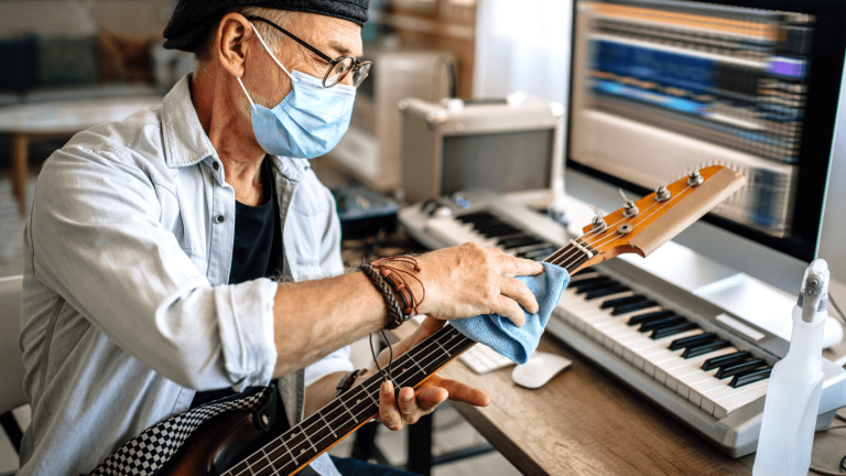 A man cleaning a bass guitar