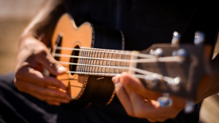 A man strumming a ukulele