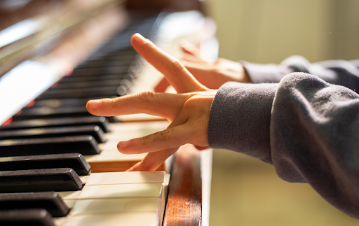 A child's hands playing a piano keyboard