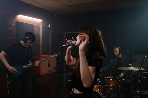 A band performs in a dimly lit studio
