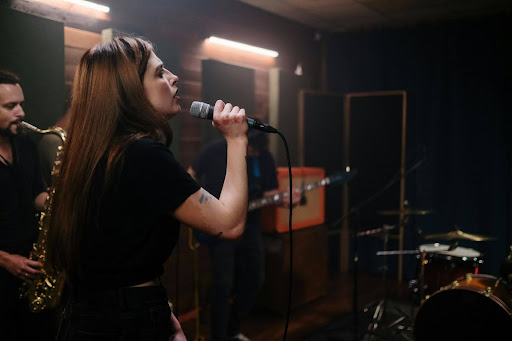 Female singer performing with a band in a studio