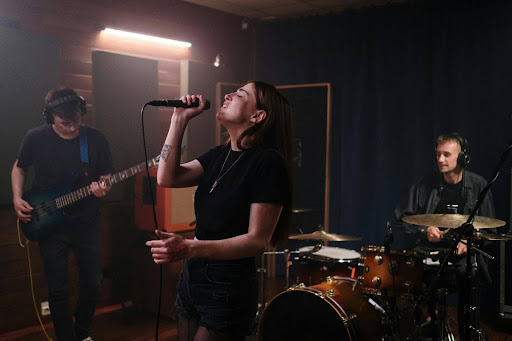 Female vocalist sings with band in studio