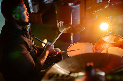 Drummer performing under warm stage lights