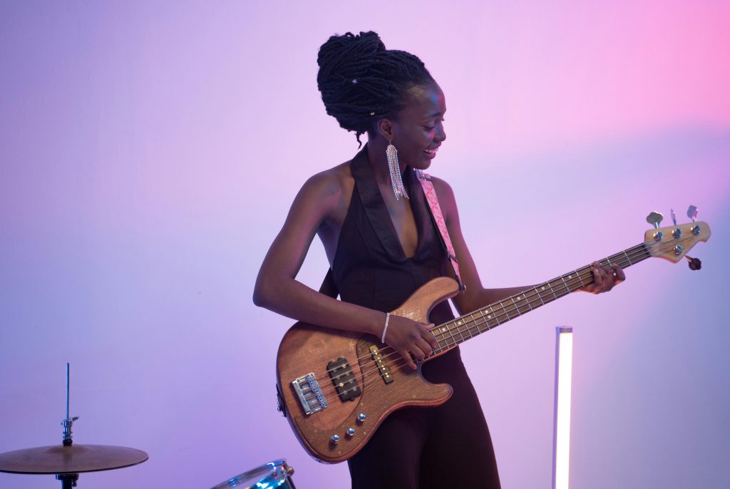 A woman playing an electric bass guitar
