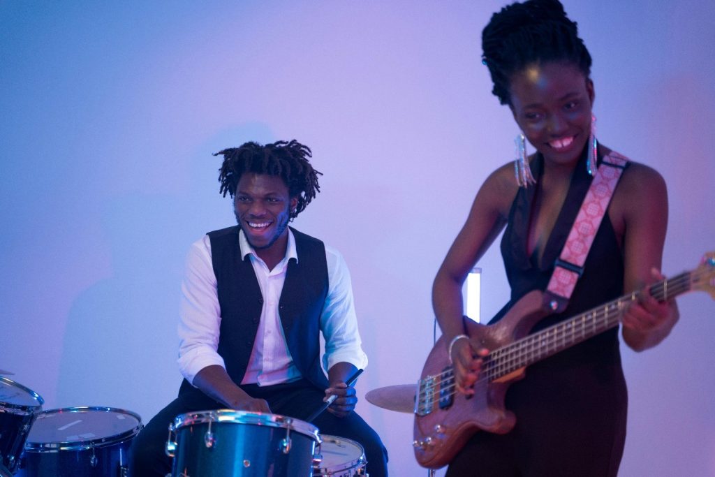 A man playing the drums and a woman playing a bass guitar