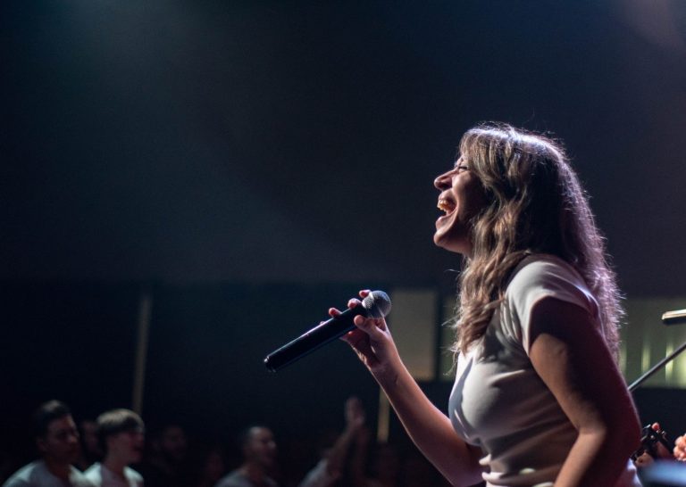 A woman singing into a microphone on stage