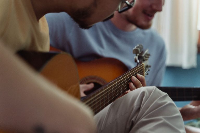Close-up of friends playing acoustic guitars together