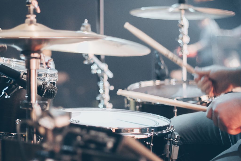 A drummer holding drumsticks and playing a drum set