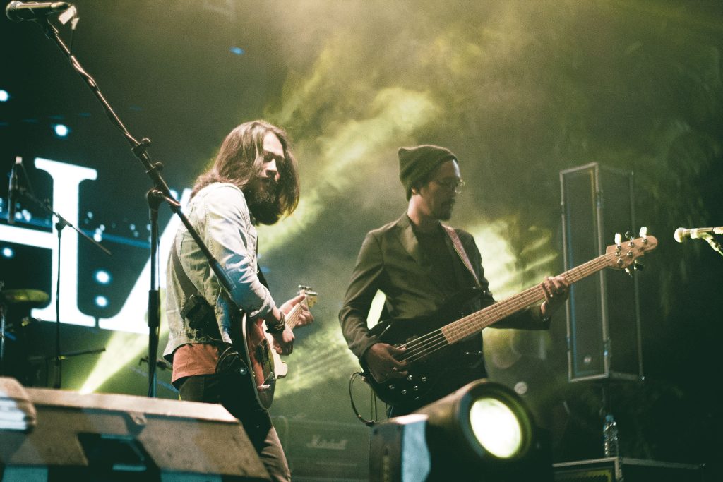Two musicians playing guitar and bass on stage
